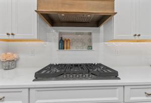 Beautiful white kitchen in Columbia, IL. Featuring a wooden exhaust hood.