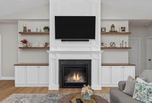 Beautiful wooden builtin shelving with white cabinets and a fireplace.