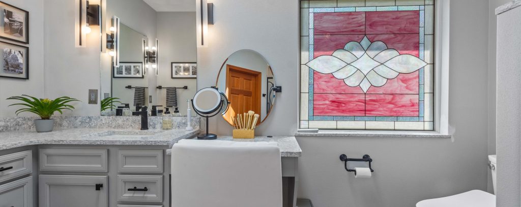 A luxury bathroom with a beautiful stained glass window.