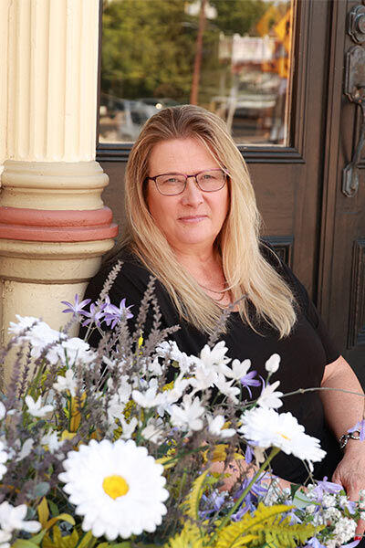 Libbie fix smiling on the front stoop of Studio 11 Cabinets & Design