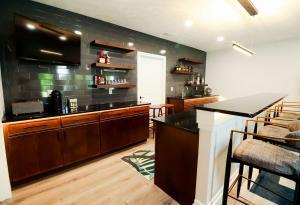 Modern basement remodel with contemporary bar area and floating shelves in Waterloo, IL.
