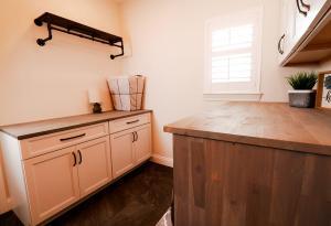 Rustic laundry room with natural wood counter tops and Ivory Koch Cabinets.