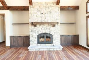 Modern Living room with a stone built fireplace and custom built-in cabinets, designed by Studio 11 Cabinets and Design.