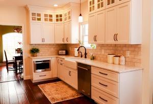 Rustic kitchen remodel with backlit upper cabinets, Ivory Koch Cabinets complete with subway tile backsplash.