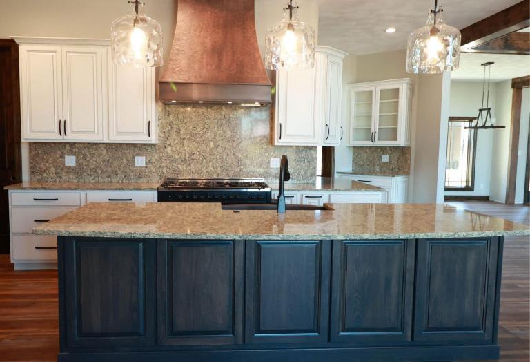 A new kitchen featuring Koch cabinets and a wooden exhaust hood.