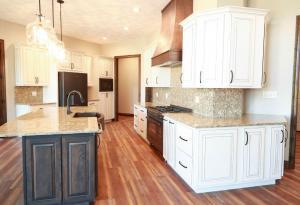 Modern farm house kitchen in Columbia, Il featuring white Koch Cabinets with the island cabinets in green.