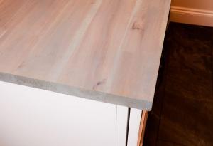 Rustic laundry room with natural wood counter tops and Ivory Koch Cabinets.
