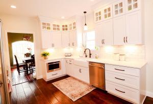 Rustic kitchen remodel with backlit upper cabinets, Ivory Koch Cabinets complete with subway tile and stainless steel appliances. Remodel kitchen design by Studio 11 Cabinets & Design.