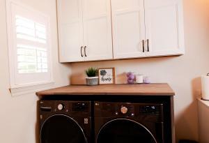 Rustic laundry room with natural wood counter tops and Ivory Koch Cabinets.