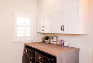 Rustic laundry room with natural wood counter tops and Ivory Koch Cabinets.