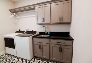 Laundry room with taupe cabinets and white appliances.